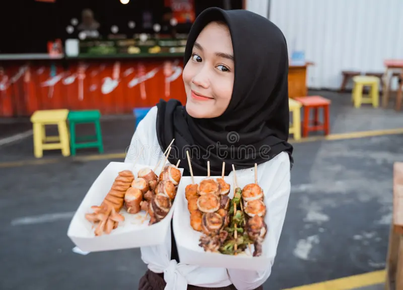 young-woman-served-korean-street-food-dish-hijab-halal-155467368